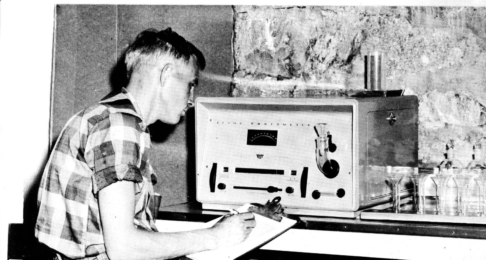 Historic photo of researcher next to lab equipment.