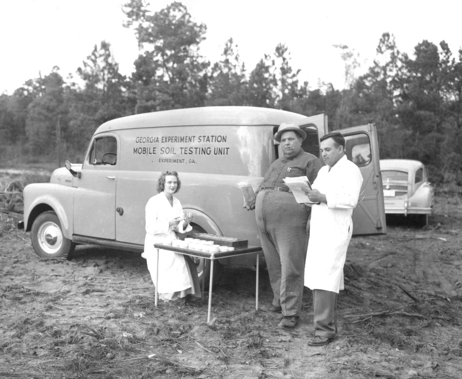 3 Researchers standing outside of Experiment Station van