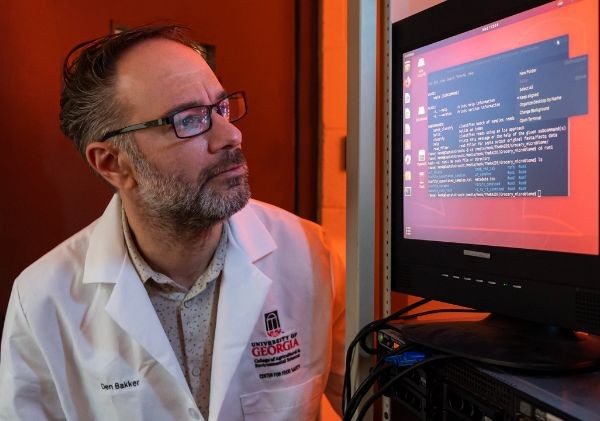 UGA Center for Food Safety professor Henk den Bakker analyzes genomic sequencing data on a desktop bioinformatics software interface in a laboratory setting.